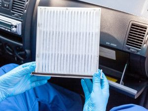 Un técnico de servicio está retirando el filtro de aire del habitáculo.