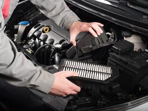 Un técnico de servicio está desmontando el filtro de aire del motor.