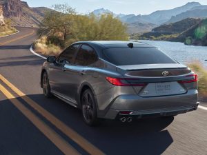 Un Toyota Camry Hybrid de 2026 circulando por una carretera rural de dos carriles.