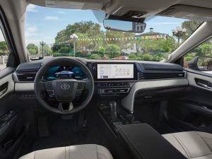 Interior del Toyota Camry Hybrid 2026, en el que se aprecian el volante y la consola central.