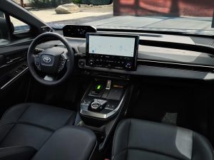 Interior del SUV eléctrico Toyota bZ 2026, en el que se aprecian el volante y la consola central