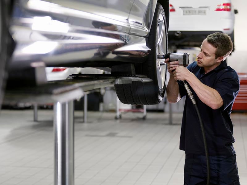 Mecánico realizando un servicio de rotación de neumáticos.